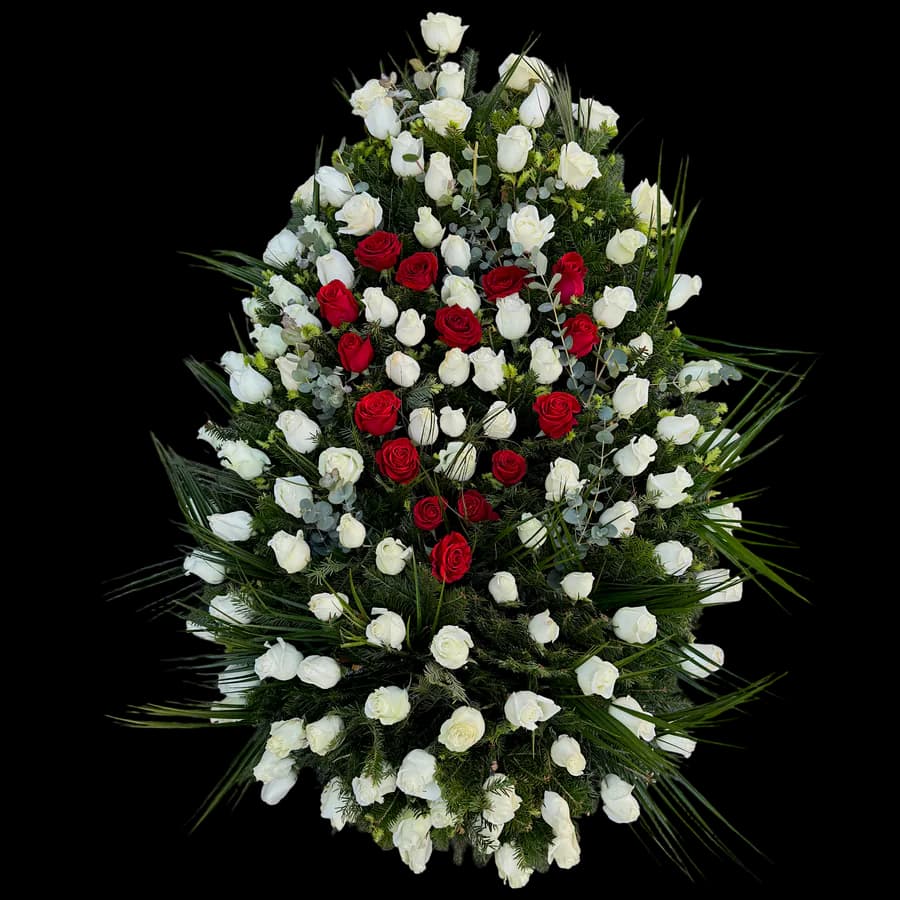 Coroână funerară mixtă cu trandafiri albi și roșii pe fond de palmier și brad
